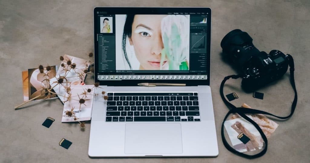 a laptop and dslr camera on a concrete table 