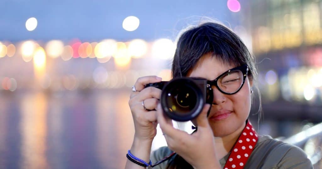 woman holding camera at night 